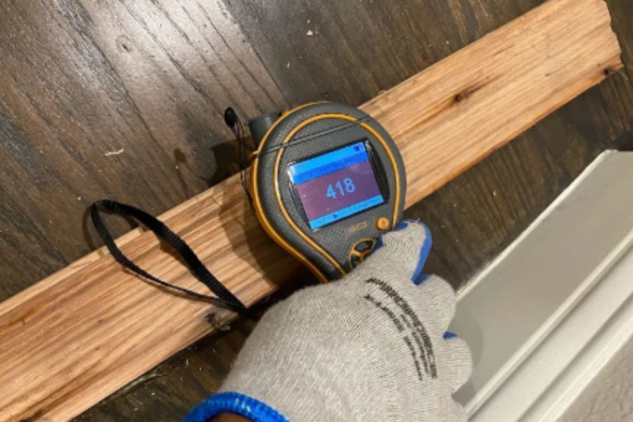 Professional moisture reading and baseboard removal during water damage restoration