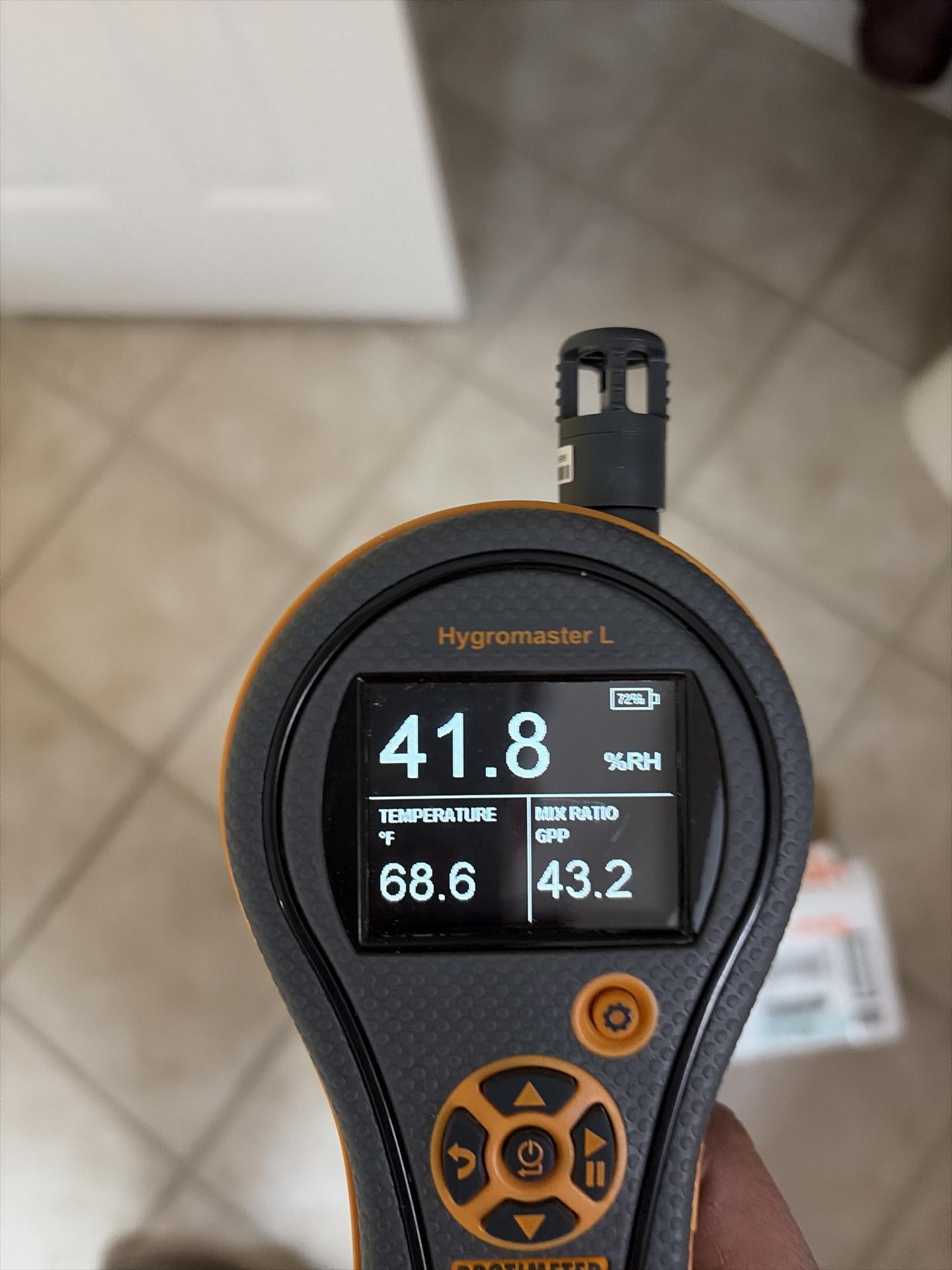 Technician measuring ceiling moisture levels
