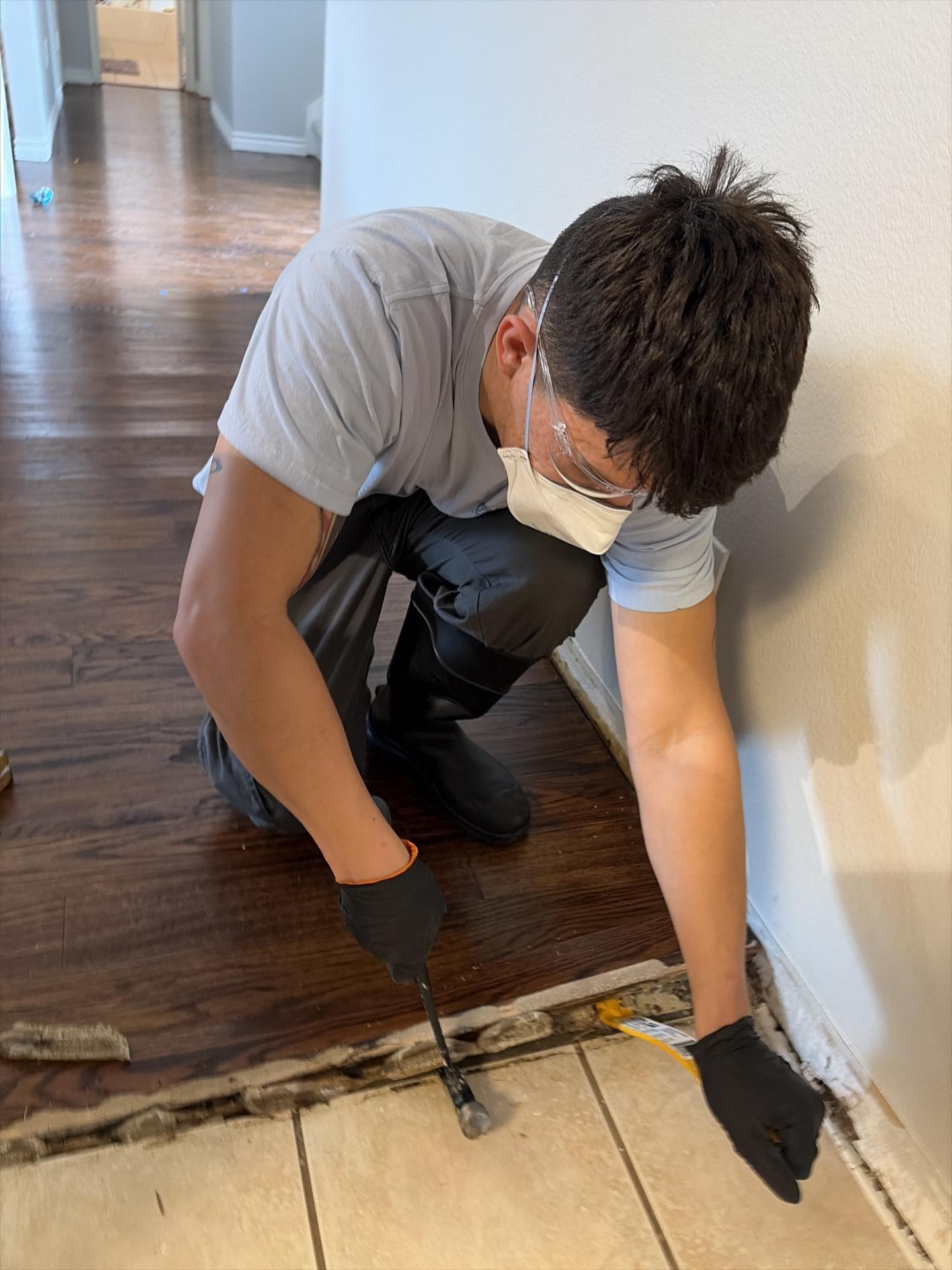 Water-damaged hardwood flooring being removed during mitigation in Allen TX home