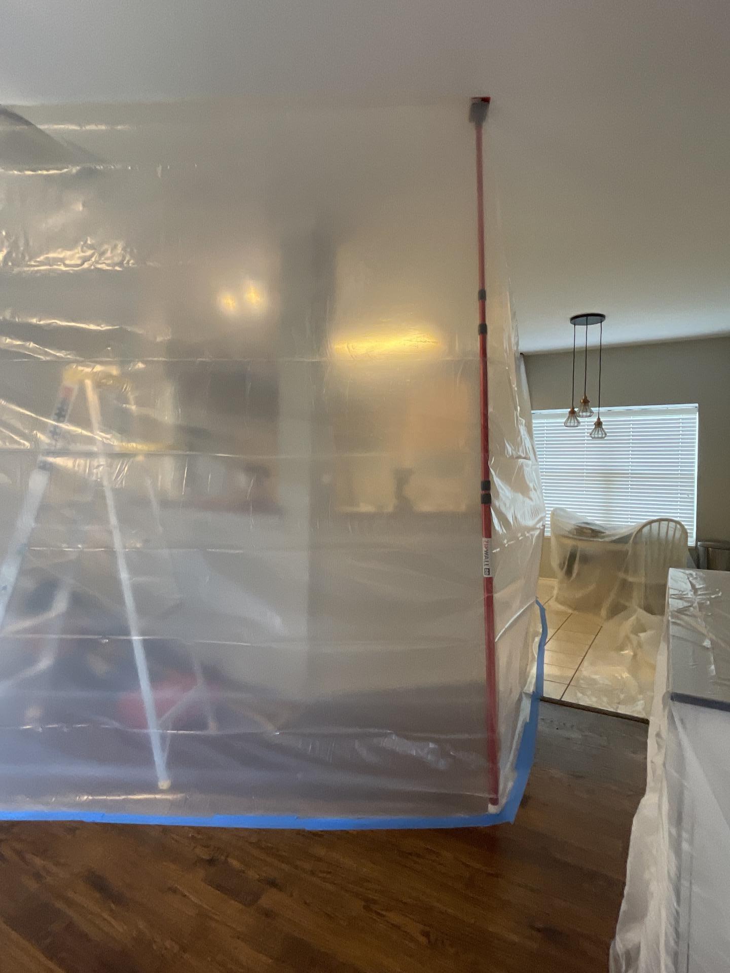 Containment barriers installed in living room to isolate water-damaged areas