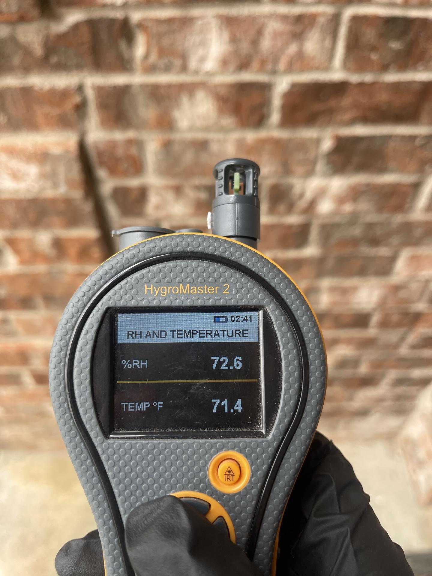 Technician taking exterior moisture readings to monitor drying progress
