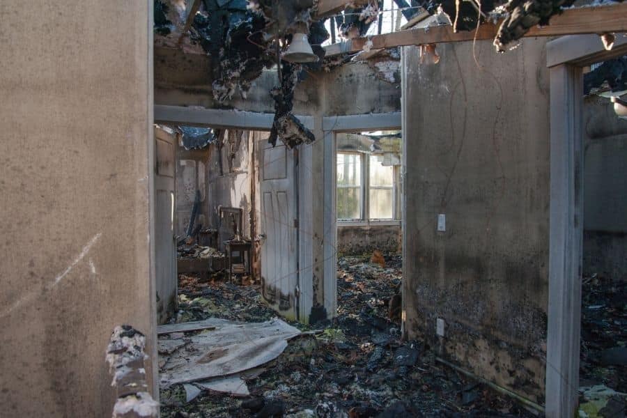 Severe fire damage to the interior of a residential home showing charred walls and structural damage