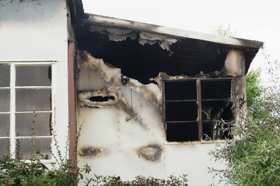 Exterior view of a residential home showing visible fire damage to the structure