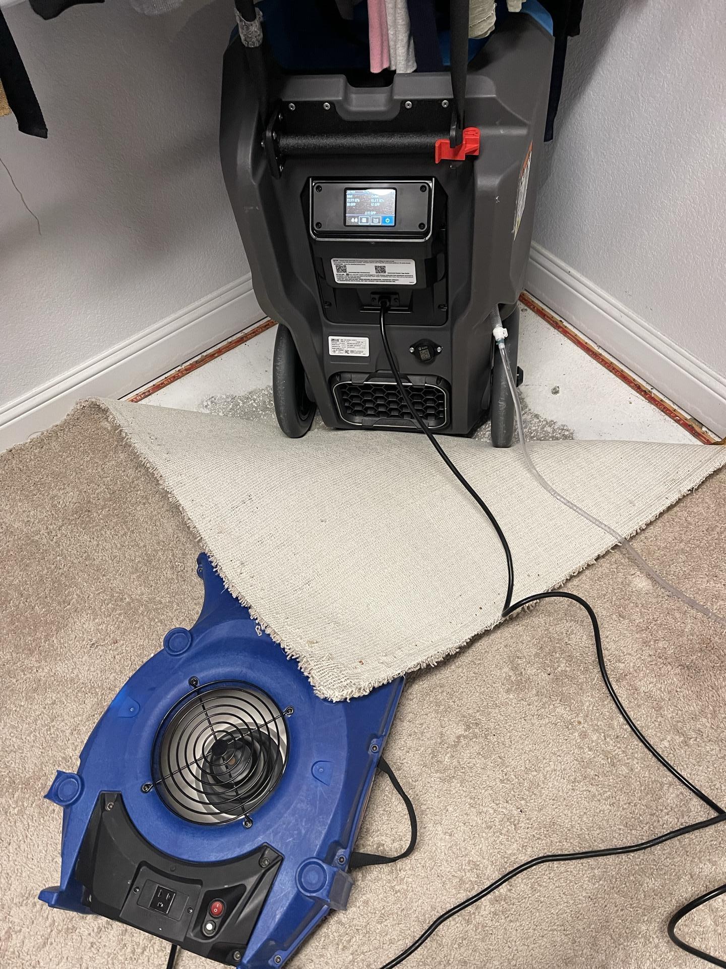Master closet carpet pulled back with drying equipment during water damage restoration