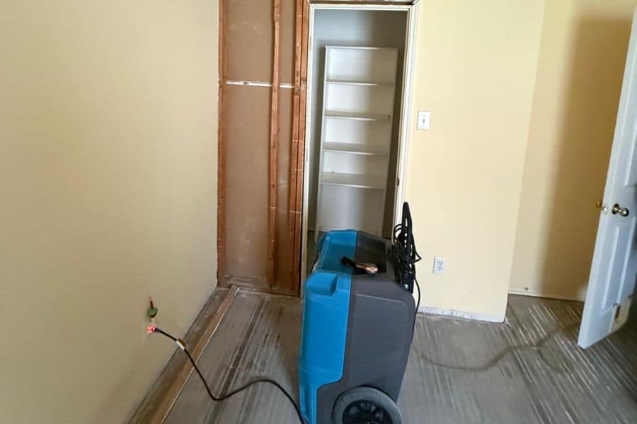 Restoration technician setting up drying equipment after a plumbing failure in a DFW home