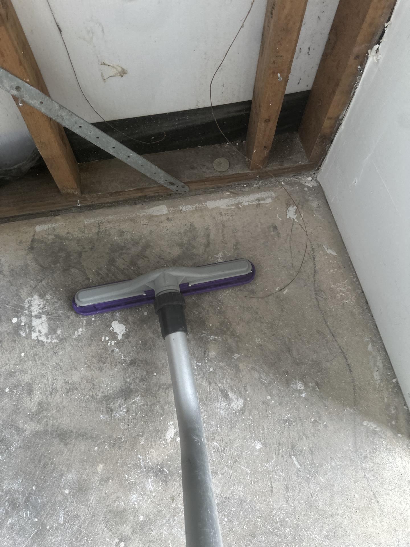 Technician extracting standing water from a flooded outside closet
