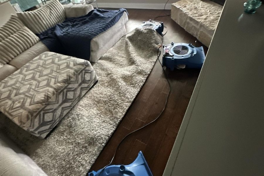 Professional air movers and dehumidifiers drying out a water damaged room during a residential restoration job