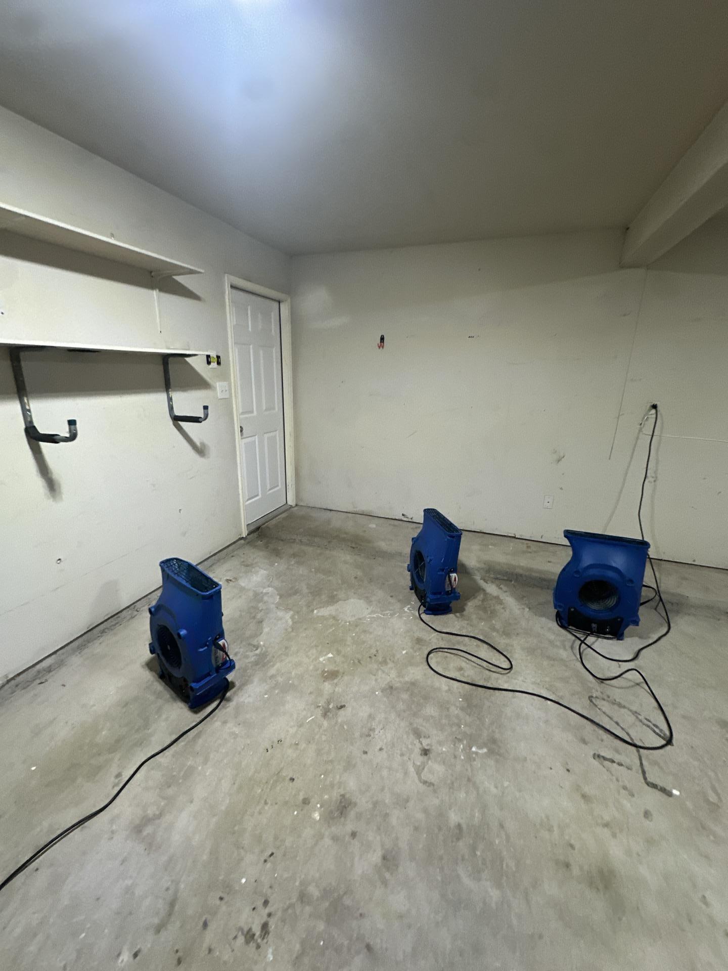 Drying process underway in the garage after water migrated from the laundry room