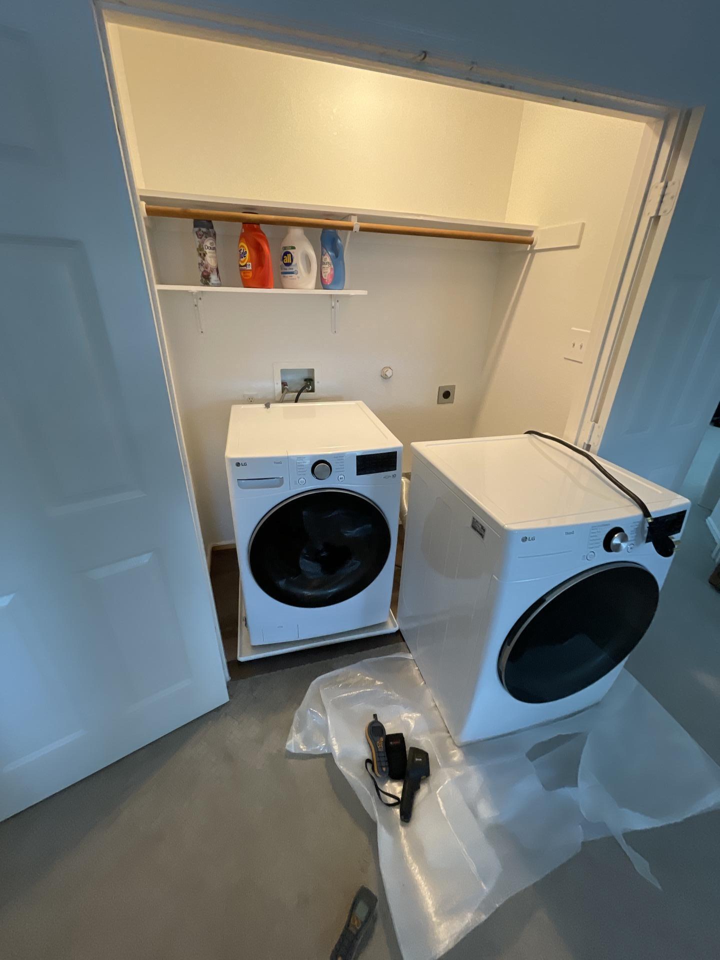 Water damage across the laundry room floor from a washing machine drain leak