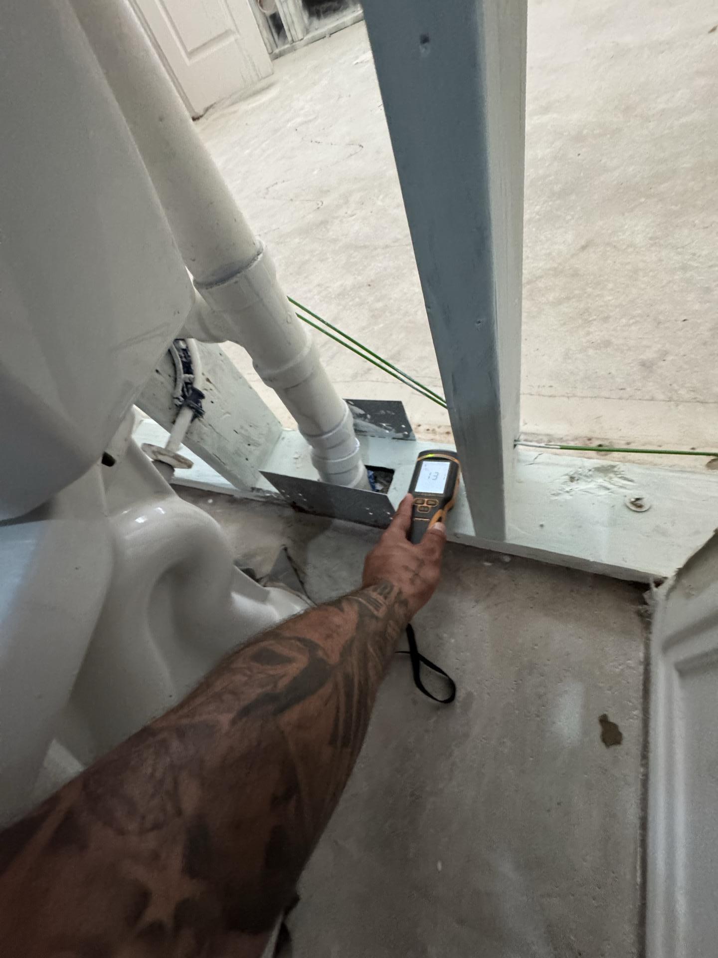 Technician taking a moisture reading during bathroom demo and mold remediation