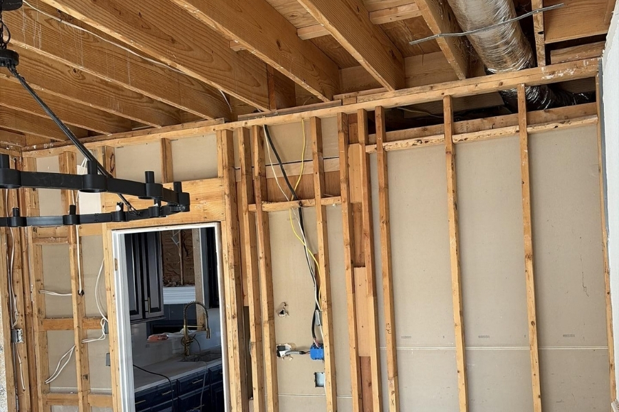 Full drywall demo showing exposed framing during structural water damage repair on a Plano home