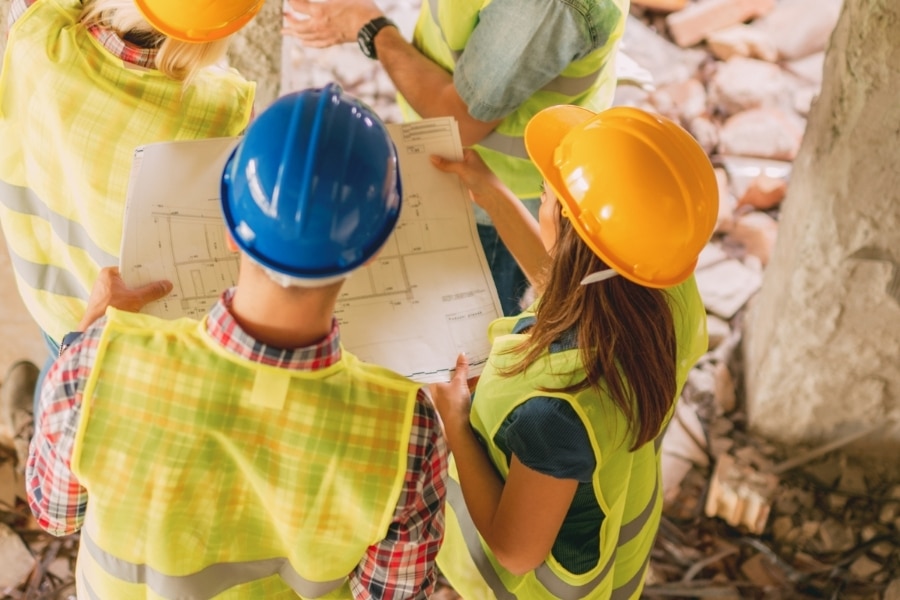A reconstruction team reviewing project plans and a timeline for a home rebuild in Plano